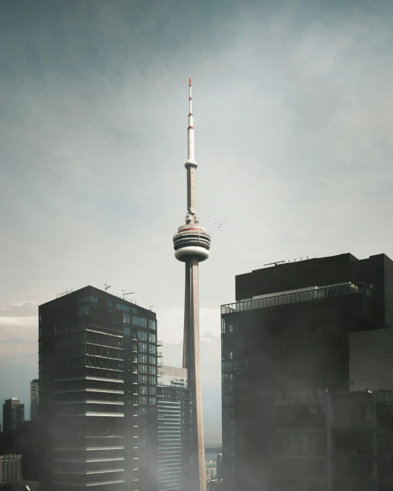 a tall tower stands in the middle of two other buildings