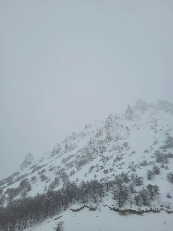 a lone skiier sits on the snow covered mountain