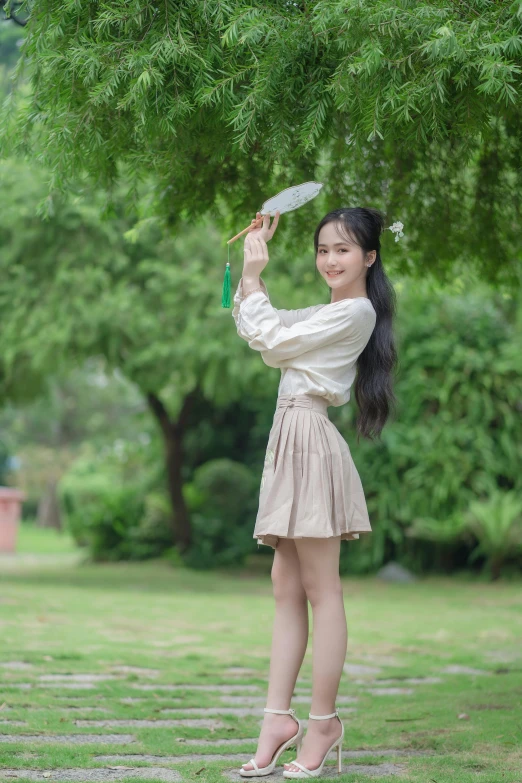 a woman is standing under a tree holding an umbrella