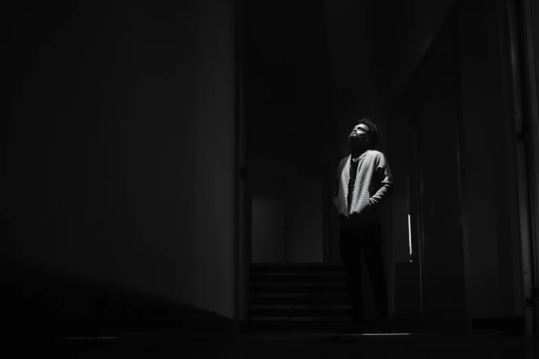 a man is standing alone in a dark room