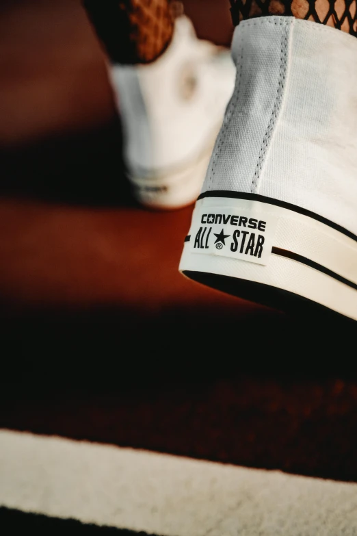 someone is tying a string to a converse sneaker