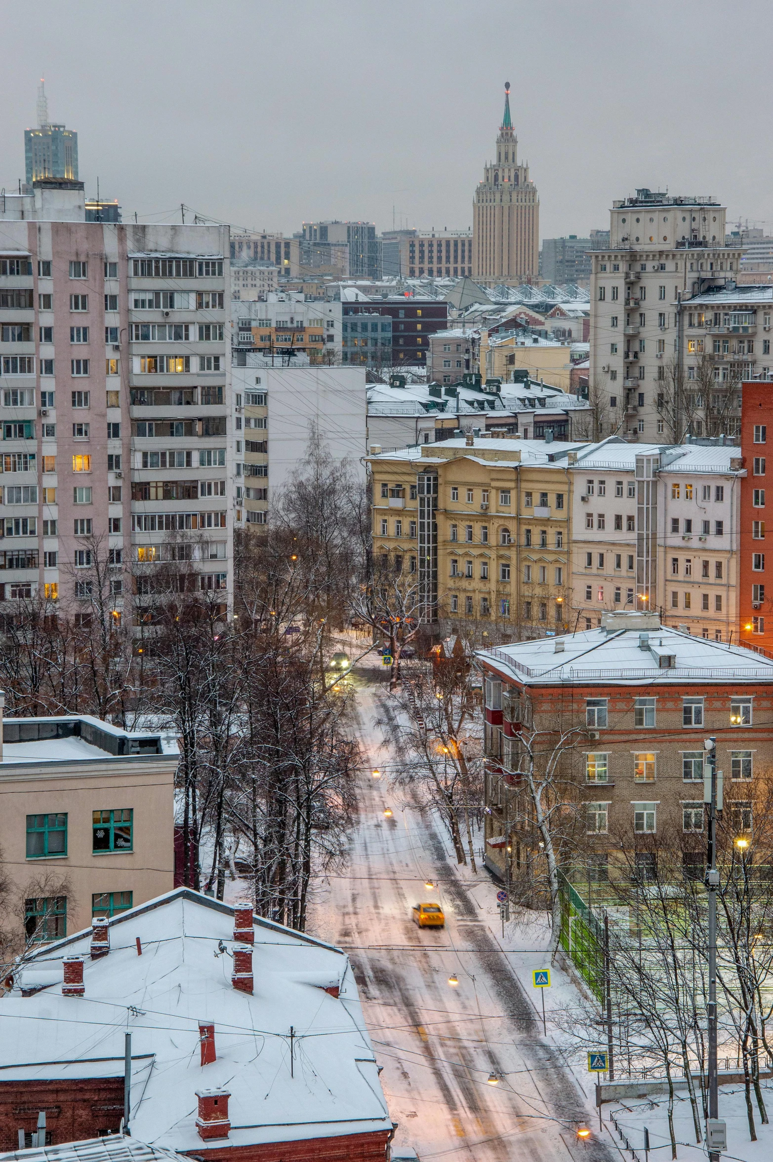 view from a rooftop in a city with snow on it