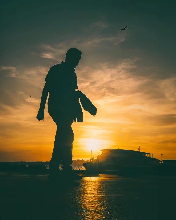 a silhouette of a person standing in the middle of a body of water with a sunset behind him