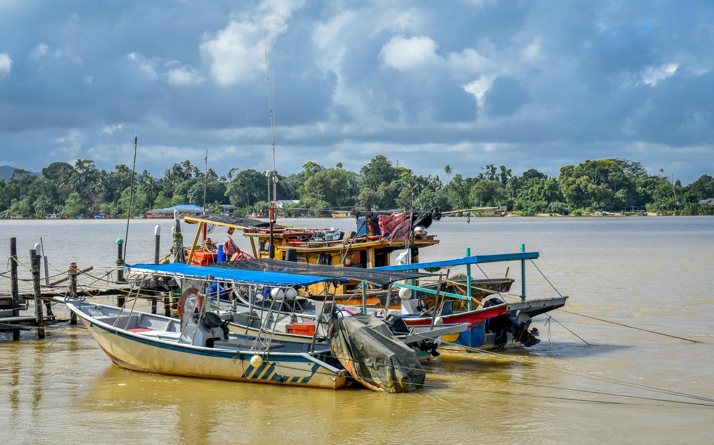 a group of four boats are tied to a dock