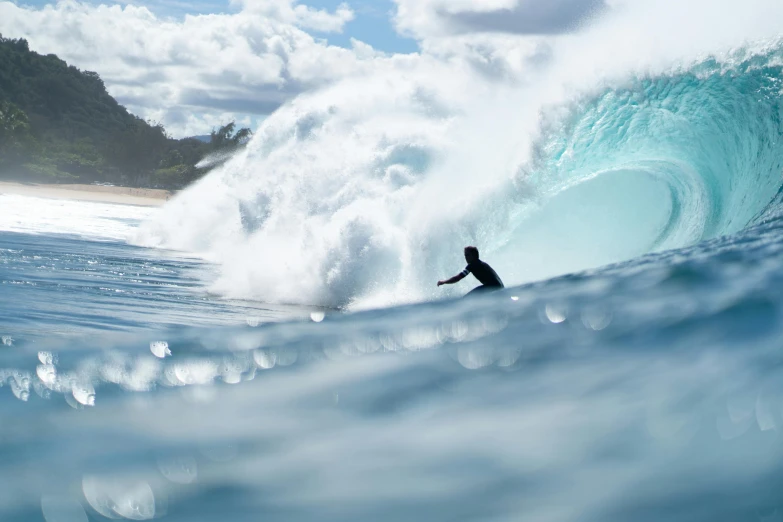 a person in wet suit riding a wave on water