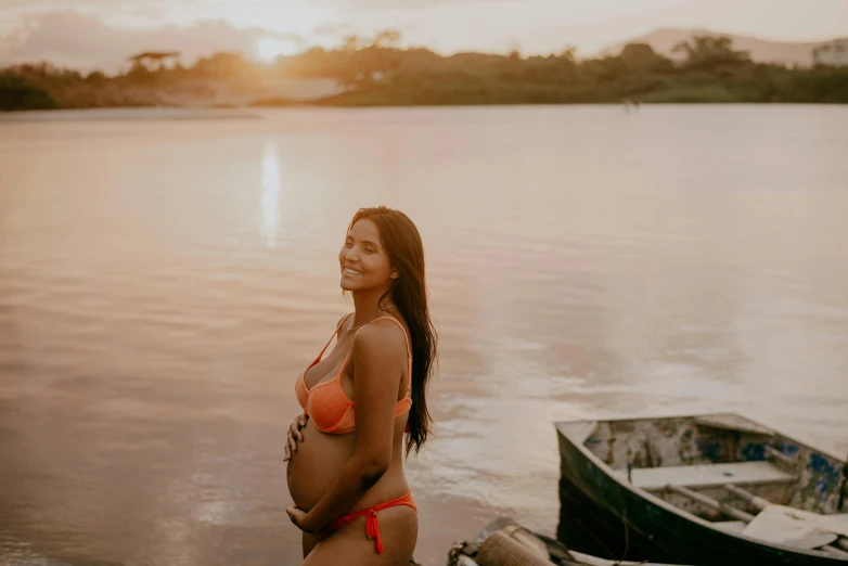 a woman stands in the water by a boat