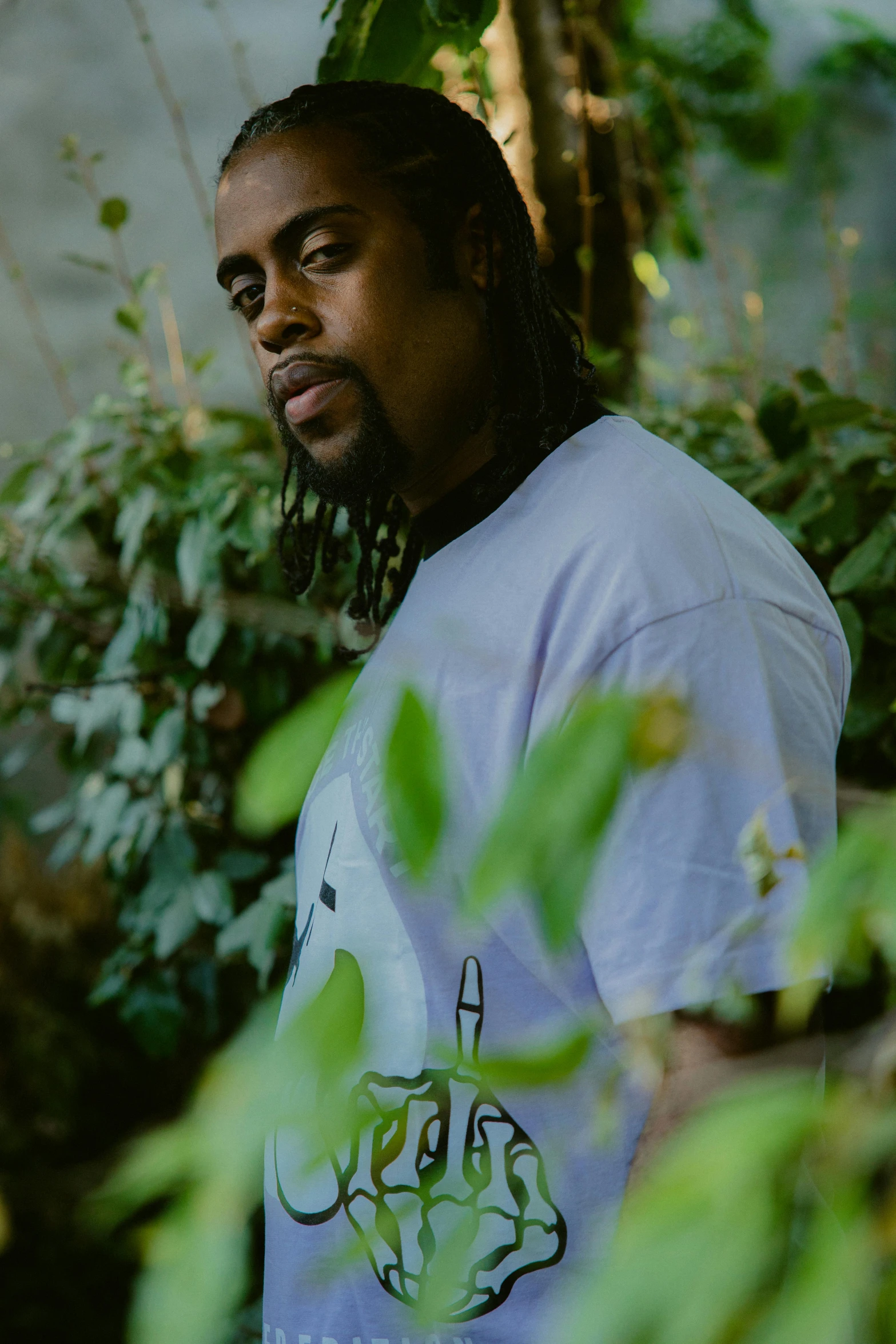 a man with dreadlocks and a white shirt on