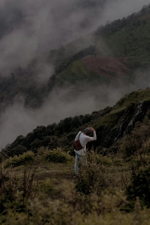 a person standing on top of a grass covered hillside