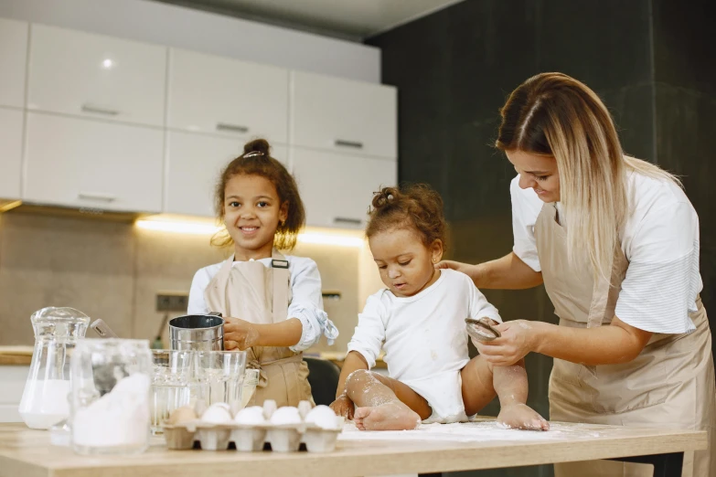 the mother is tending to her two daughters in the kitchen