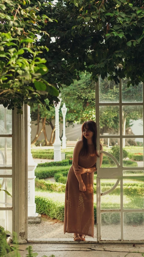 a woman is standing outside an open window