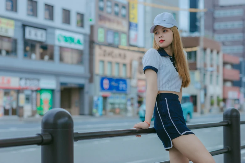 a girl leaning on the fence by herself in the street