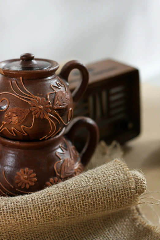 there is a brown teapot with designs on it