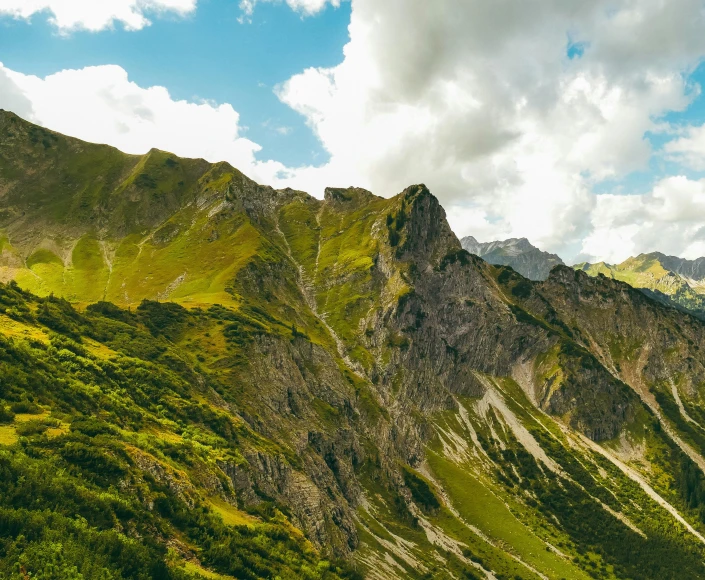 an image of mountains with trees and clouds