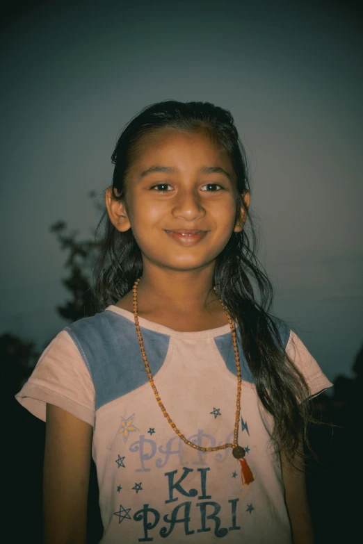 a girl wearing a shirt with a gold chain