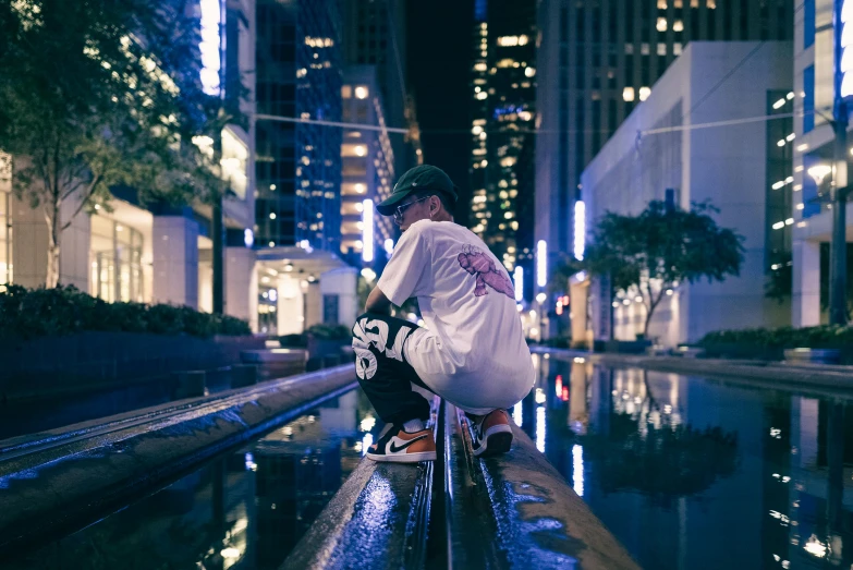 a young man riding his skateboard on a ledge at night