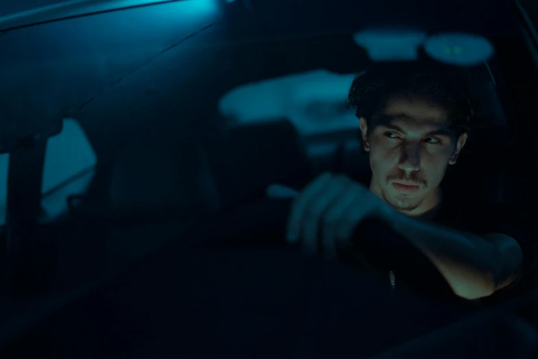 man in car on cellphone in dark area