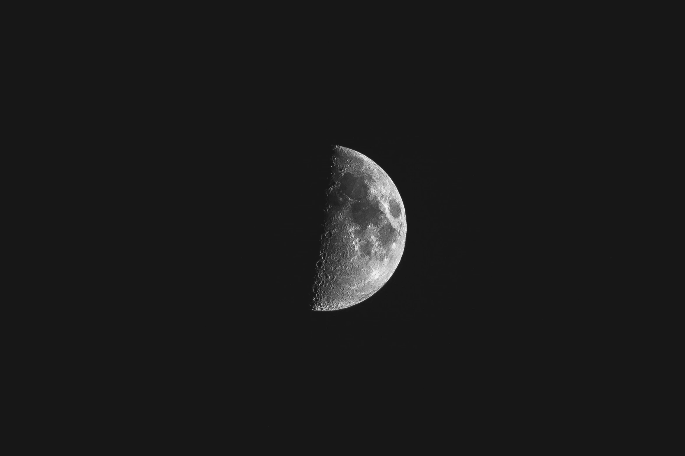 a half moon in the black night sky