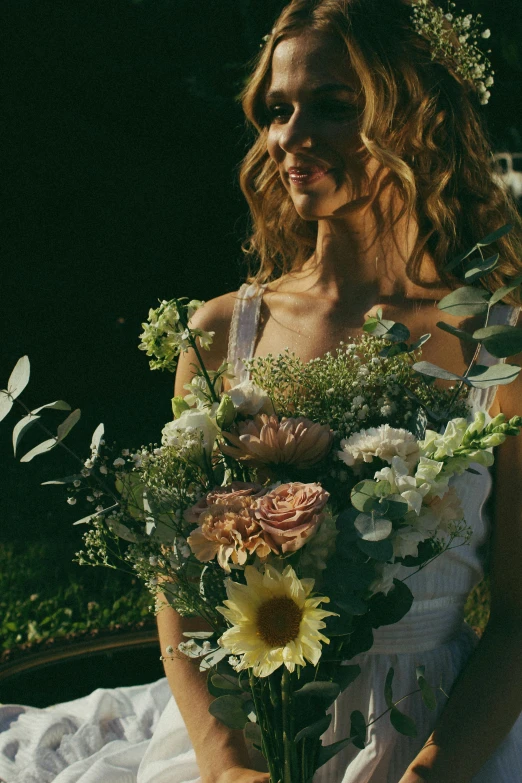 bride wearing gown holding flowers and a white cloth