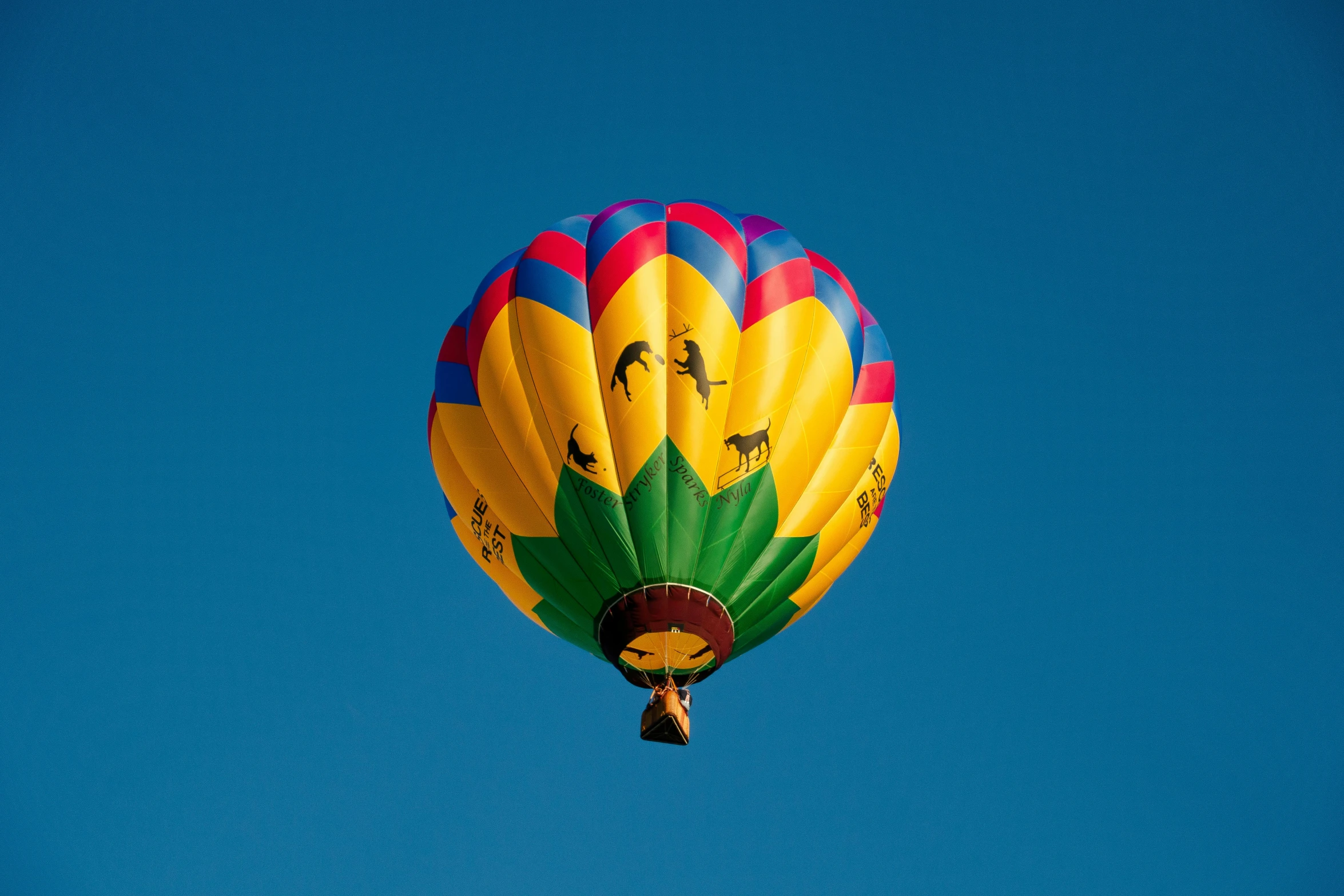 a large colorful balloon in the air with its top off