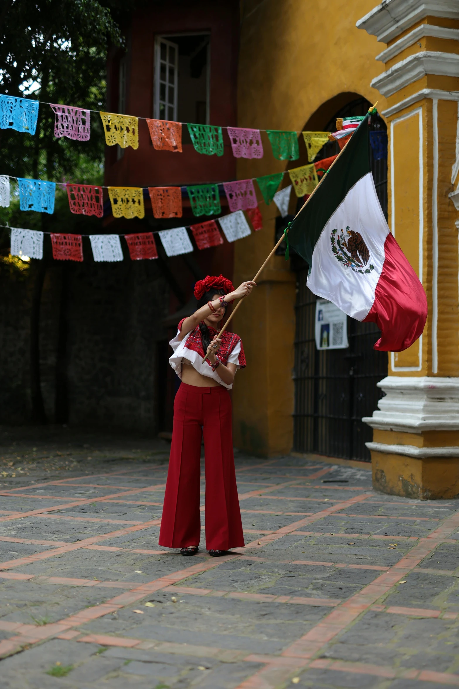 woman holding mexican flag and a large black and white flag