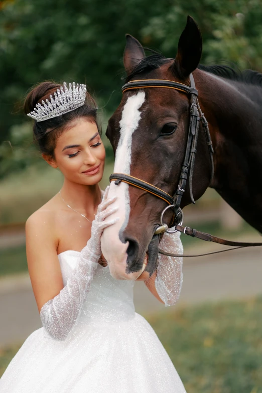 a bride pets the nose of a horse