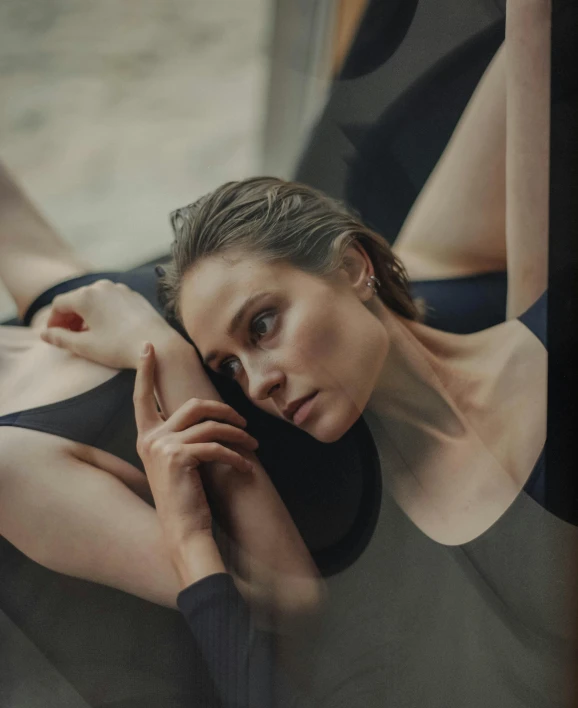 a woman in black top laying down on floor