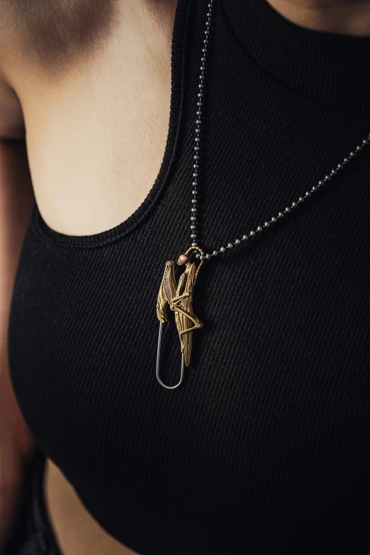 a woman in black top with necklace with a gold horse on it