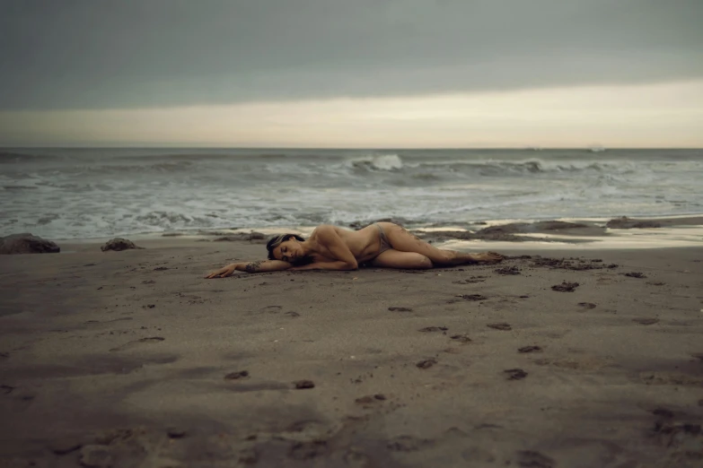 the lady is relaxing at the beach on a cloudy day