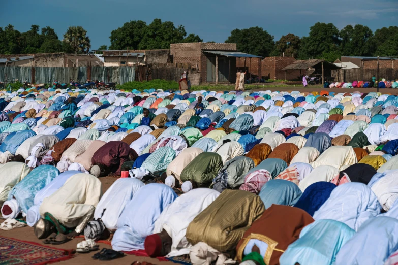 a large group of people wearing veils are kneeling in prayer