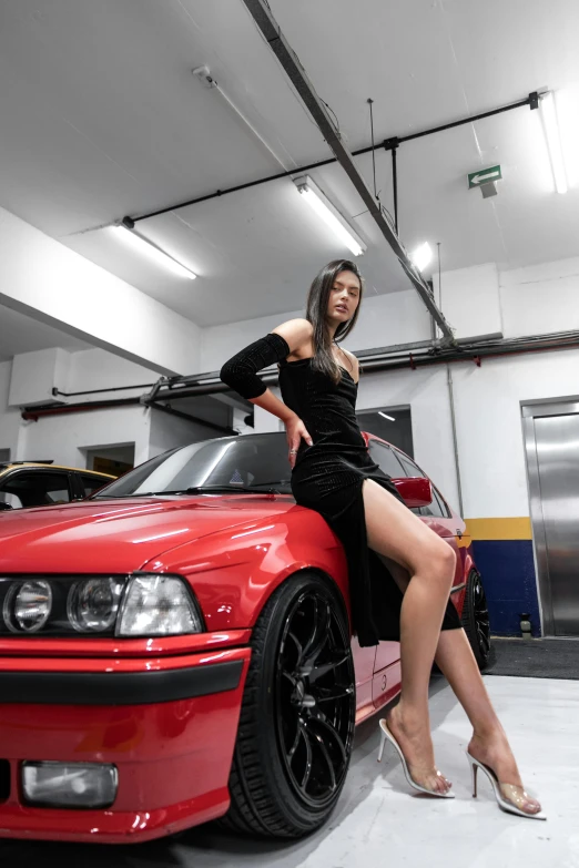 a woman leaning on a red sports car