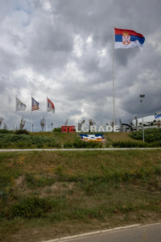 a bunch of flags flying on the side of a road