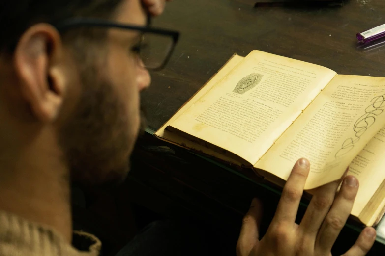 a man holding an open book with the book itself