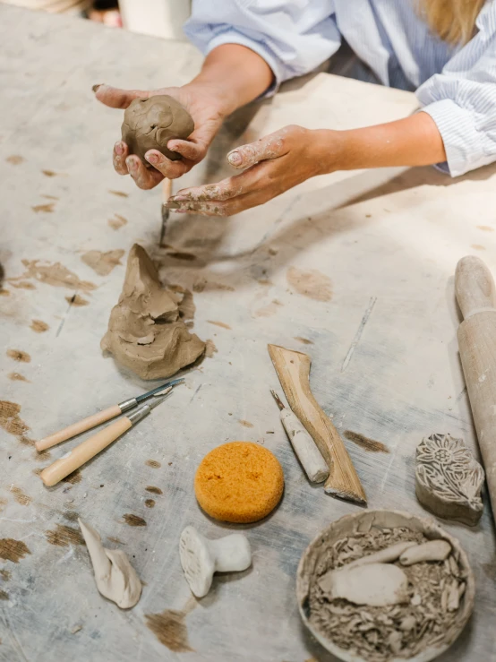 someone making pottery that is being made with clay