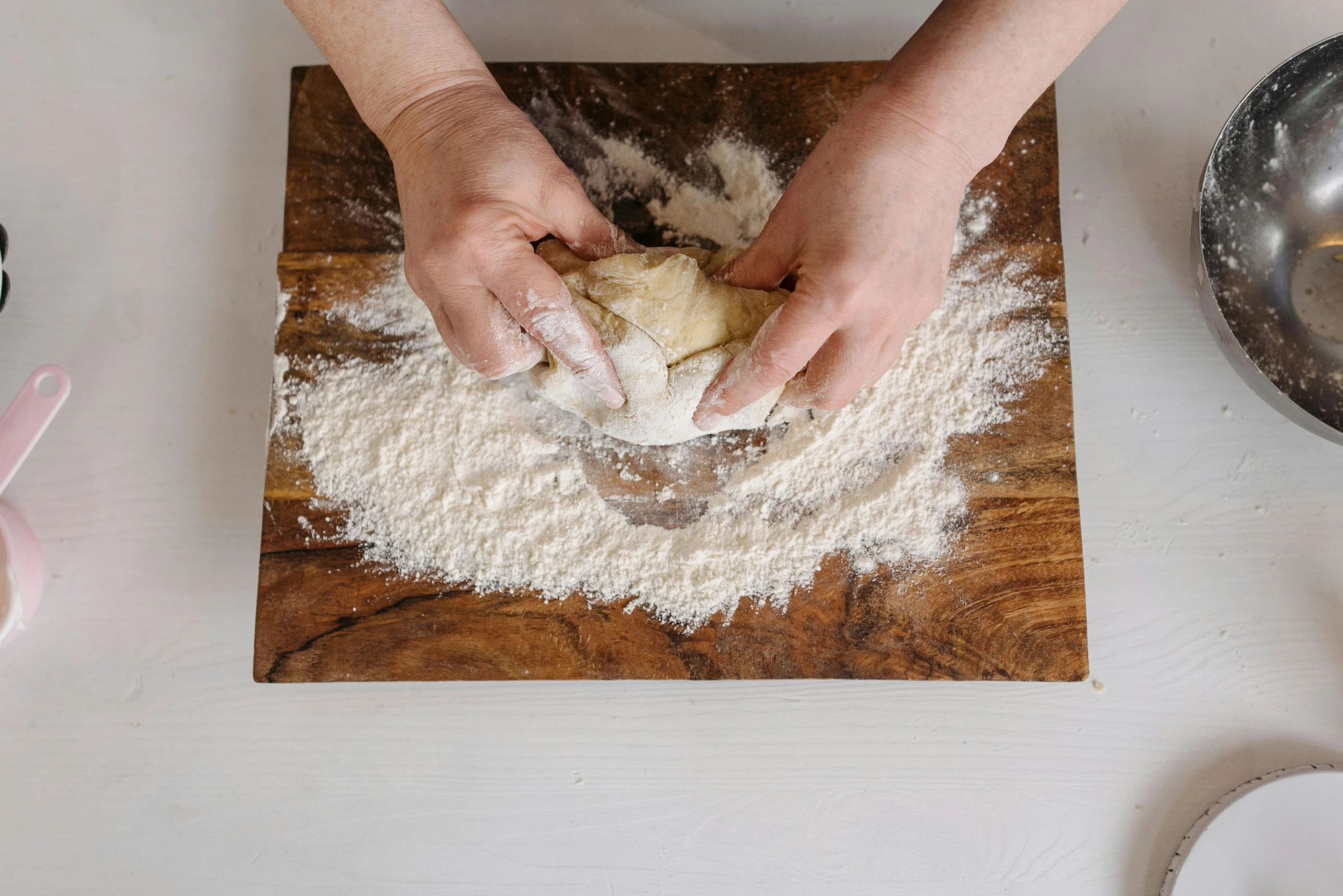 a person is using flour to knead a loaf of bread