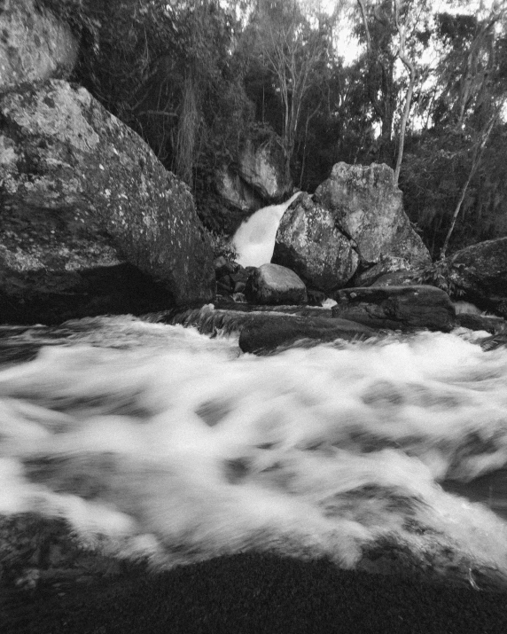 a black and white po of water moving through some rocks