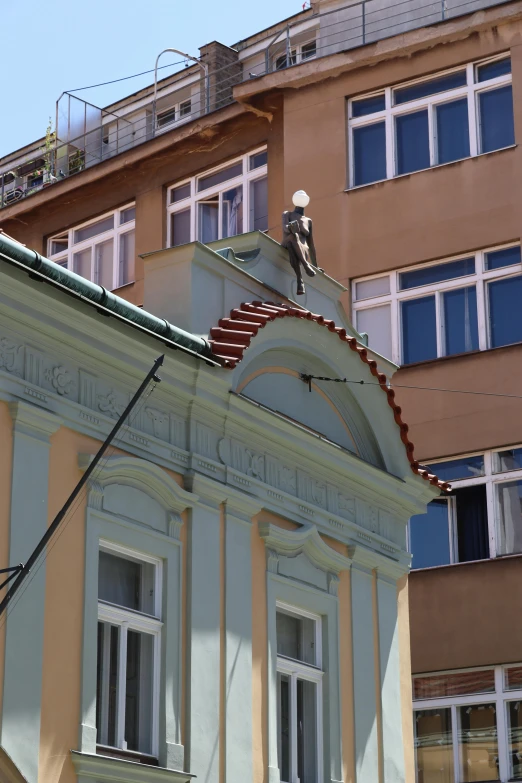 a building has a small roof with a man on it