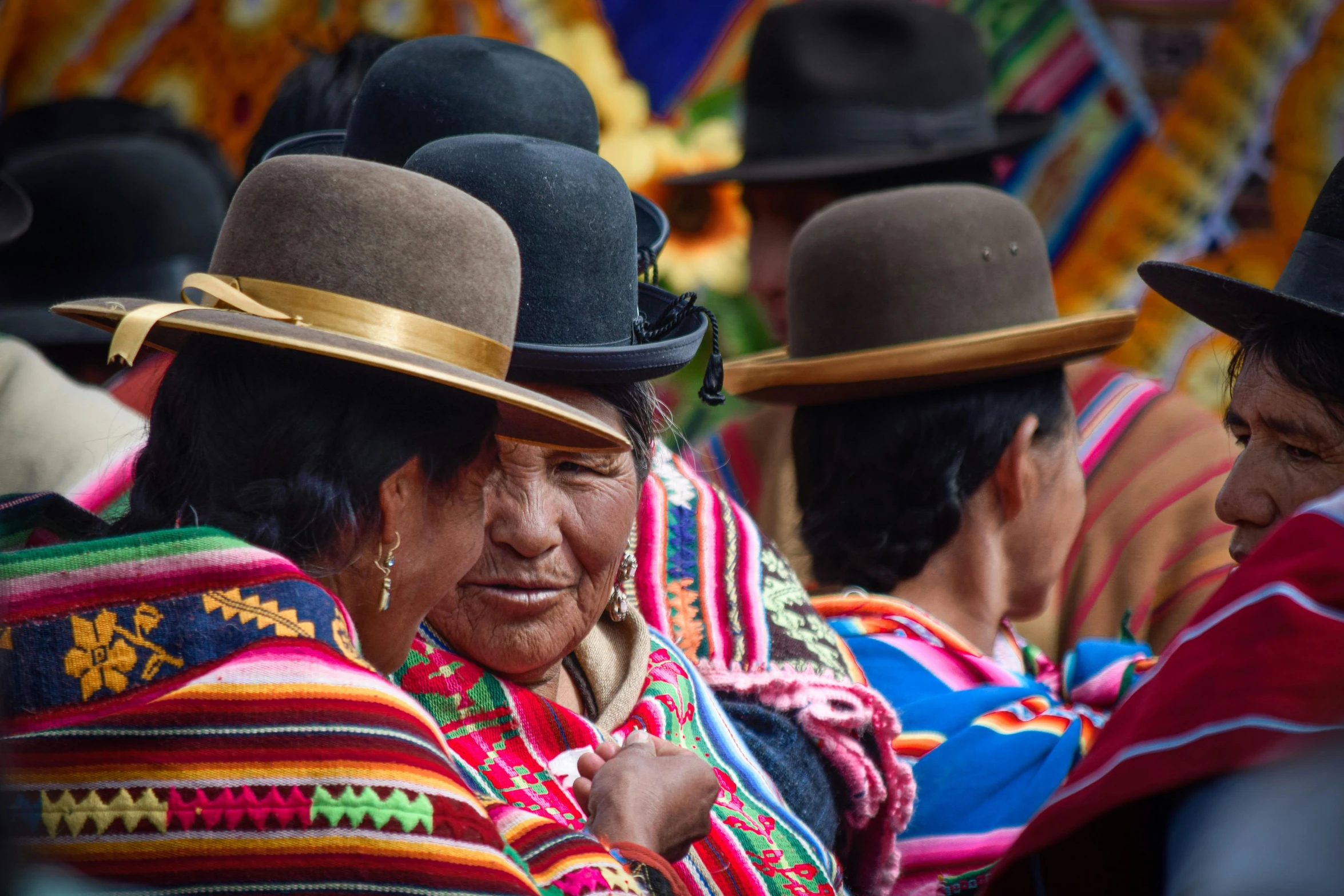 women with colorful clothing and hats and headdress in the background