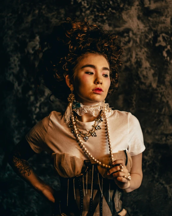 woman wearing pearls and wearing choker with black background