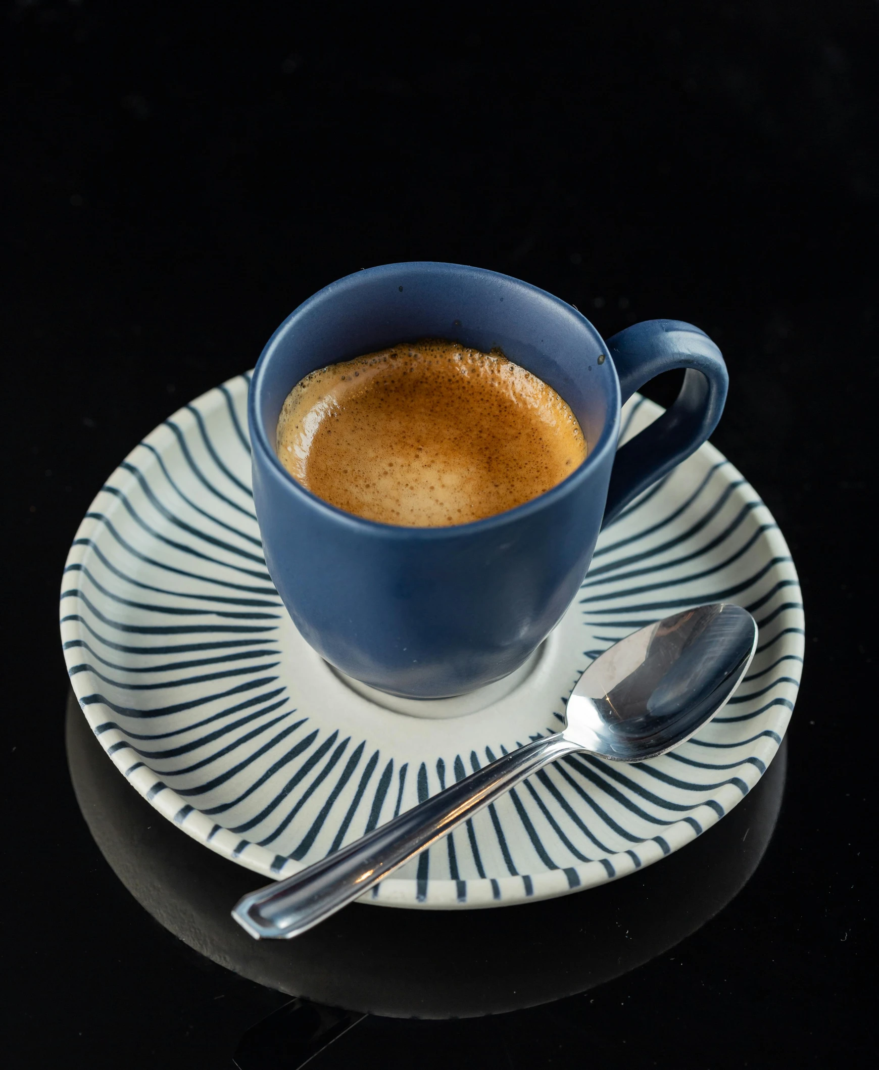 a cup of coffee sitting on top of a plate