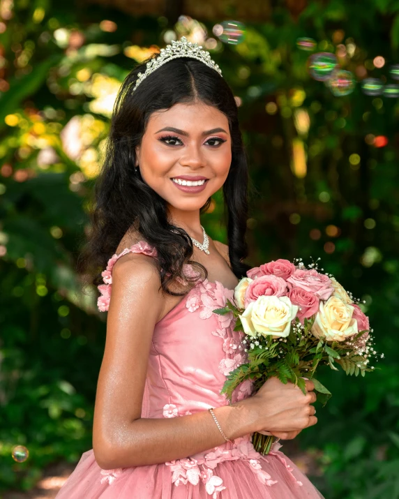 the young woman in the pink dress is holding roses