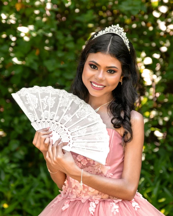 a woman in a pink dress holds an oriental fan