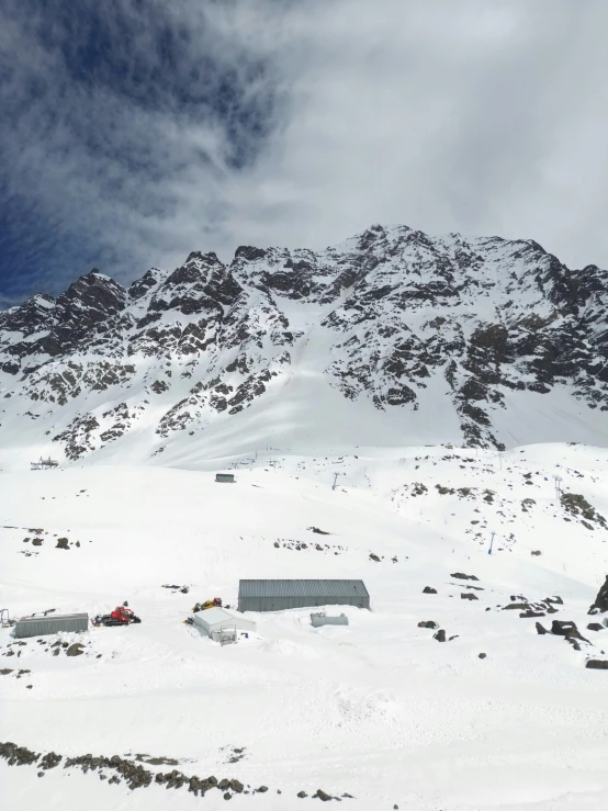 a snowy mountain side has many huts and snow