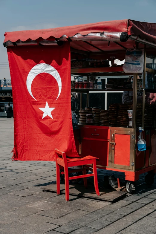 there is a man that is behind a red cart