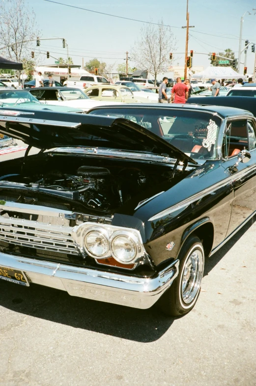 an old black american car has its hood open