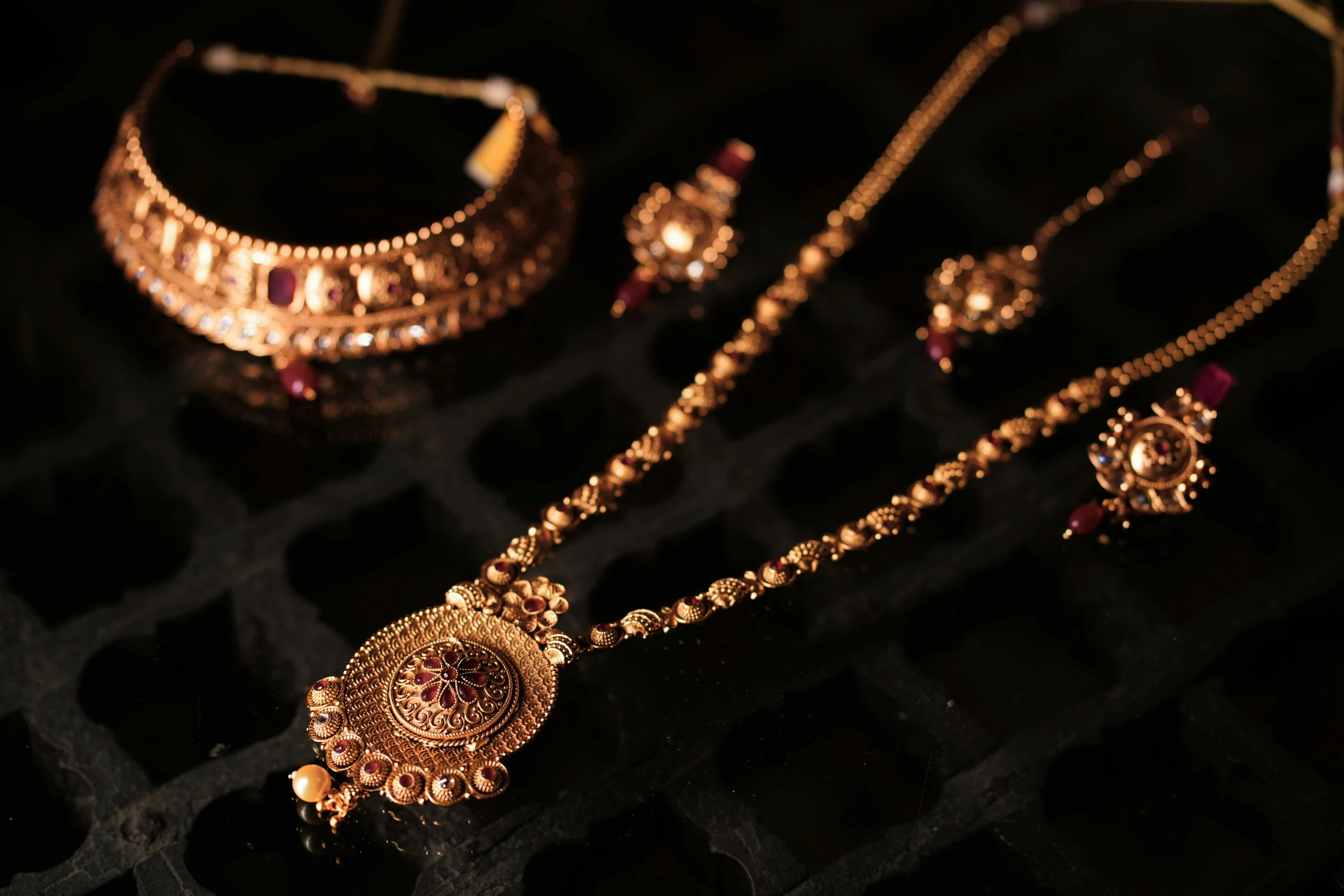 a gold jewelry collection in full display with dark background