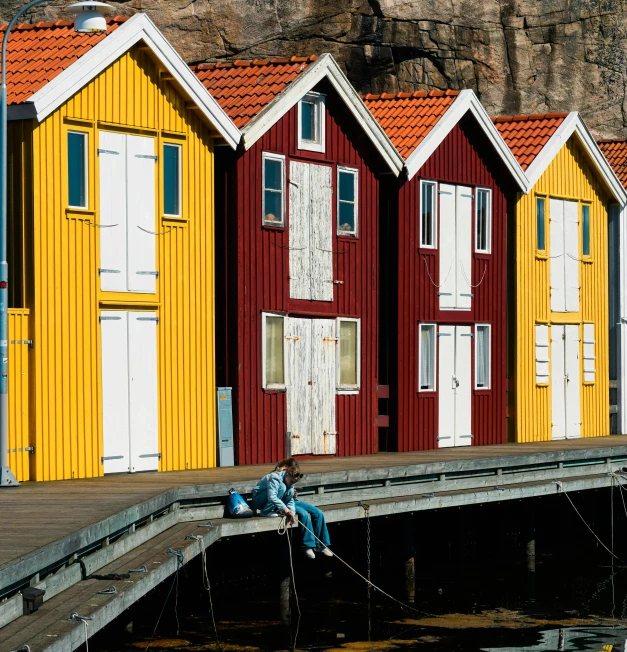 several beach huts on stilts in front of water