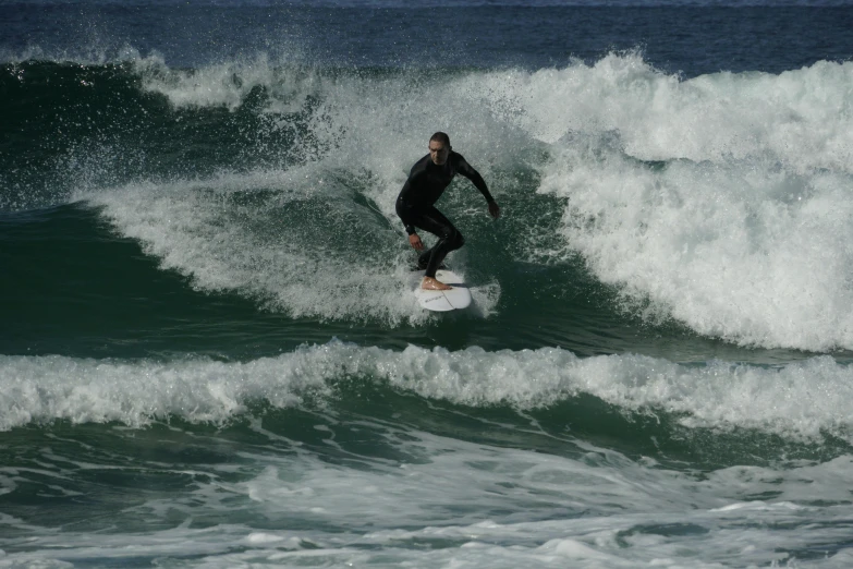 a man riding a surfboard on top of a wave in the ocean