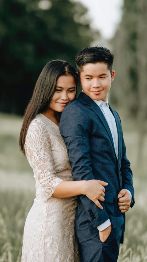 a young man is holding his pregnant wife