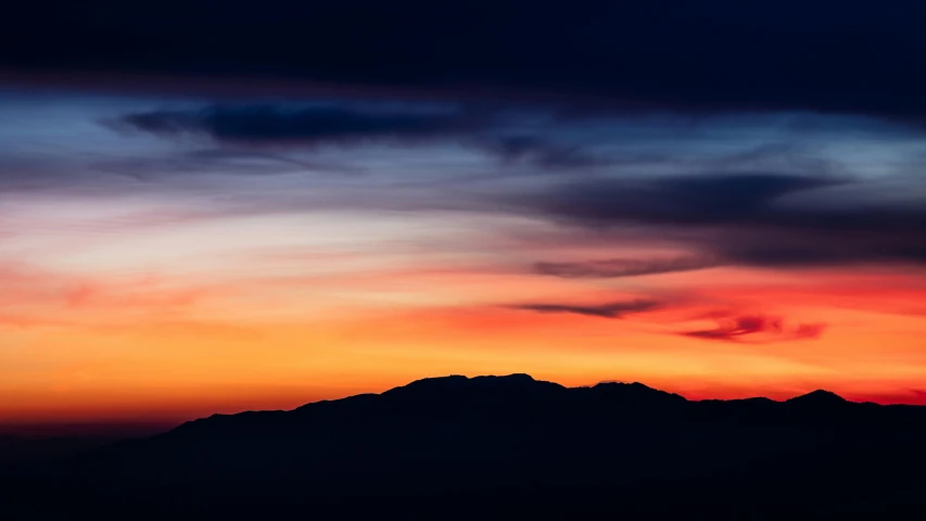 a view of the sun setting over a mountain