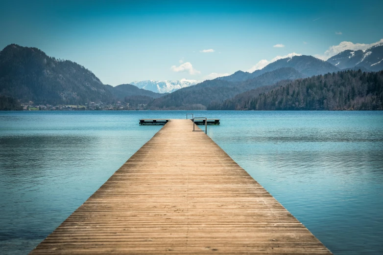 a pier stretching into the water near mountains